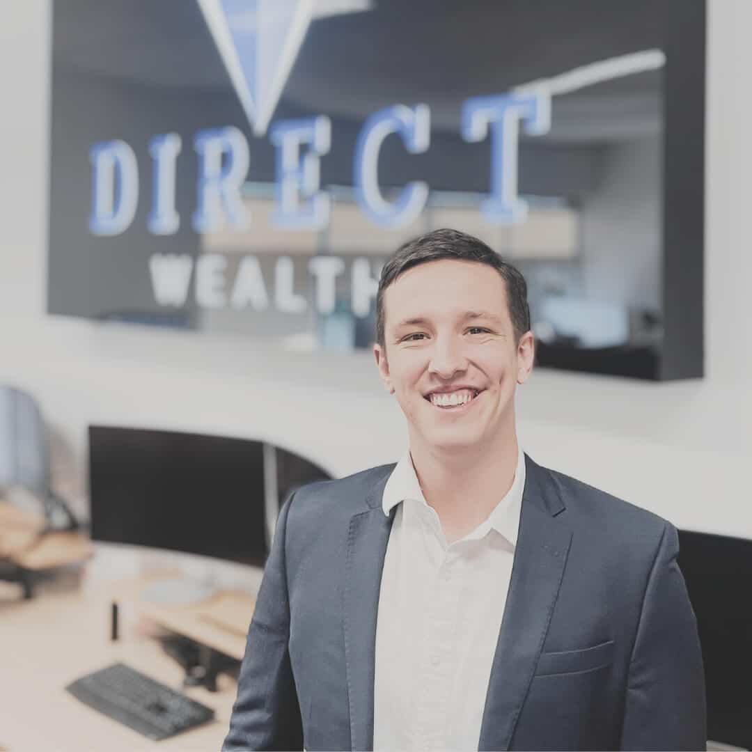 A picture of financial advisor Greg Bennet in front of the Direct Wealth light up sign.