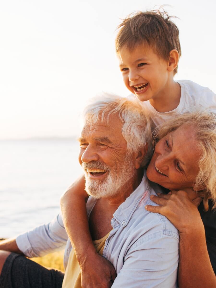 grandma, grandpa and grandson smile and laugh. His grapdparents have carefully designed their estate plan to benefit their grandson.