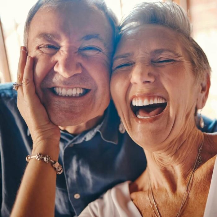A happy older couple smile and laugh for the camera